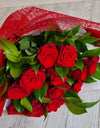 Long stem red roses with greenery wrapped in signature style